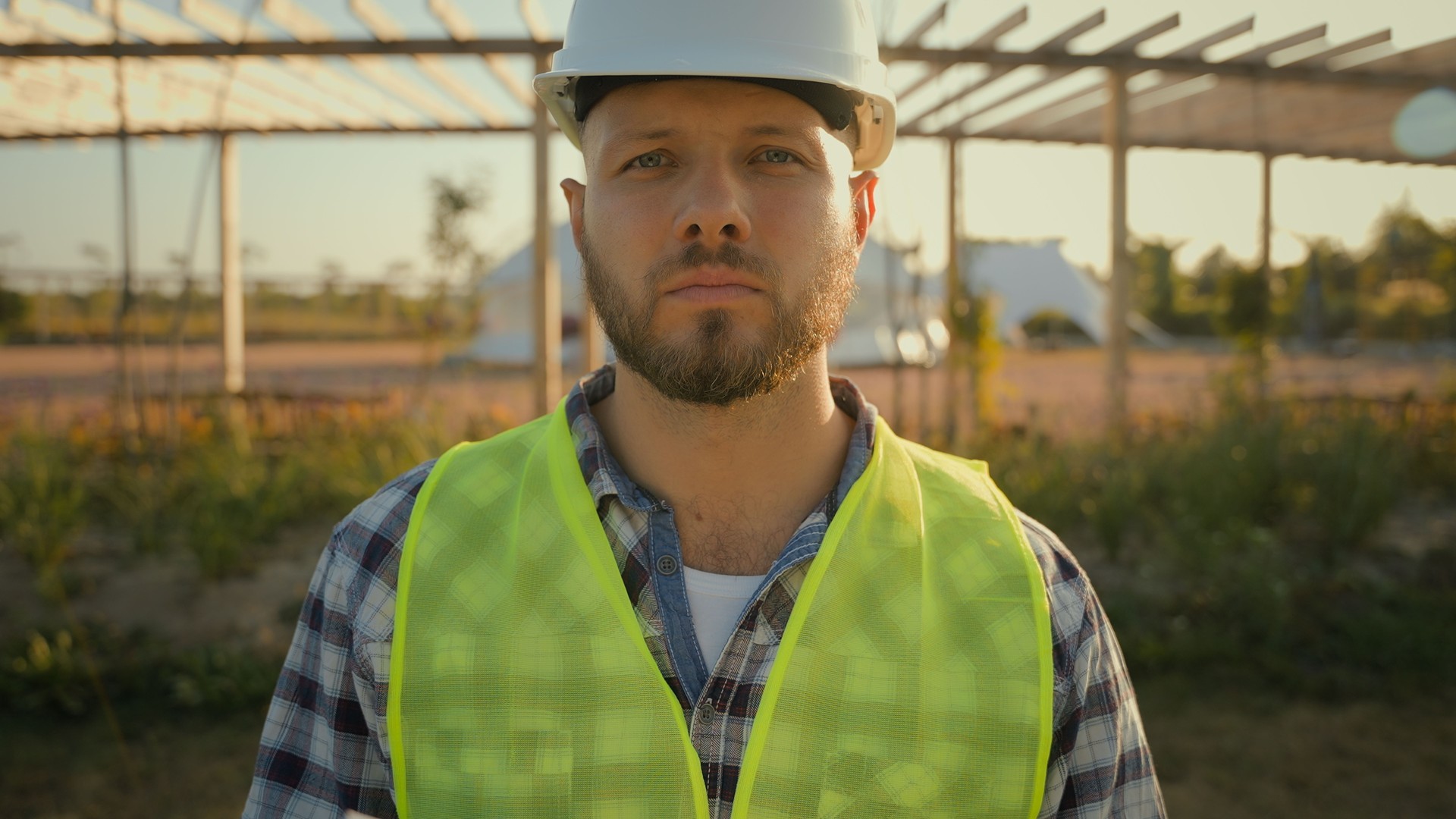 Close up portrait thoughtful serious Caucasian male engineer builder man guy controller helmet uniform hold checking tablet notebook looking camera outdoors countryside. Ecology industrial engineering